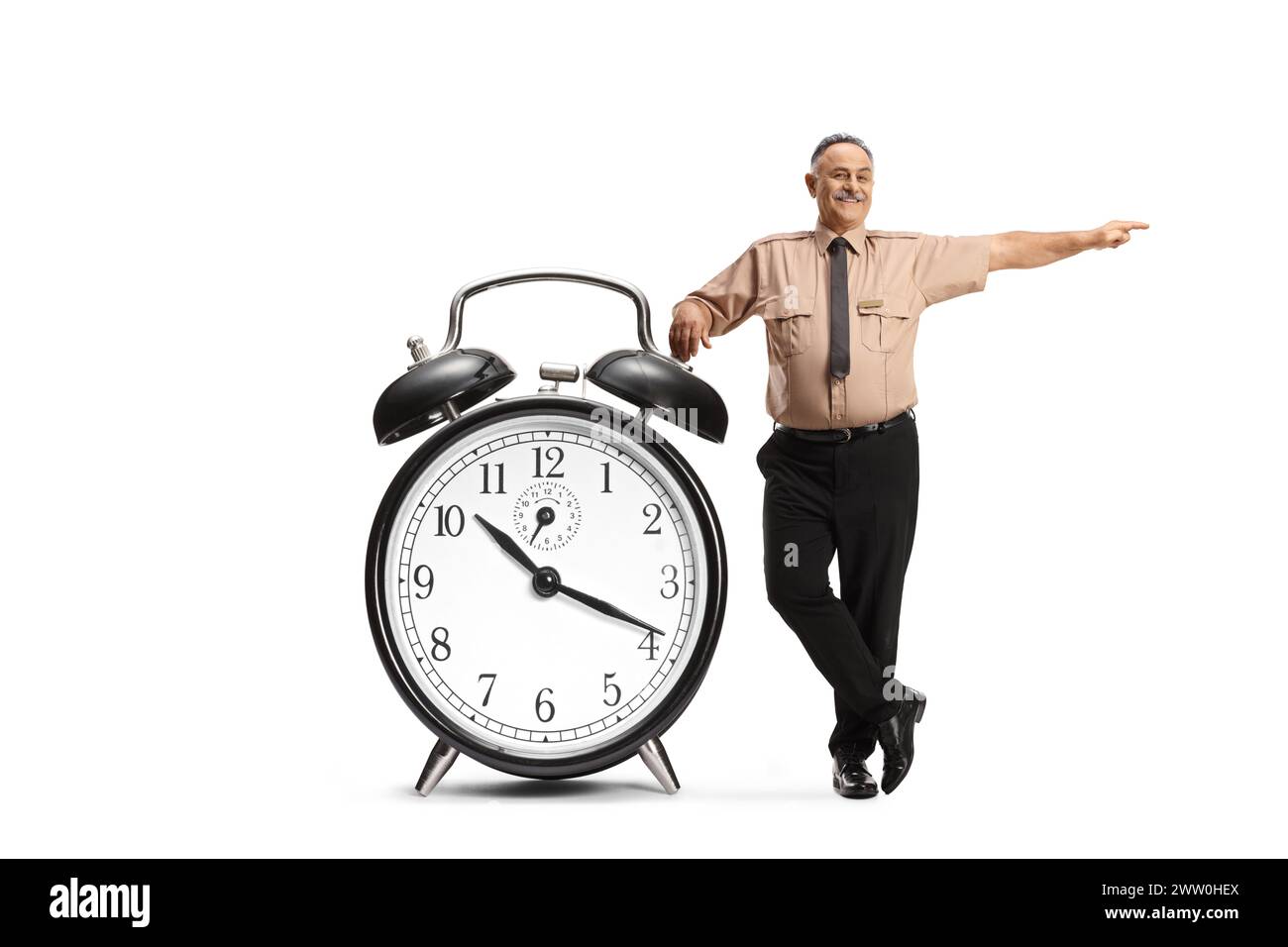 Sicherheitsoffizier lehnt sich auf einen großen Wecker und zeigt auf die Seite isoliert auf weißem Hintergrund Stockfoto