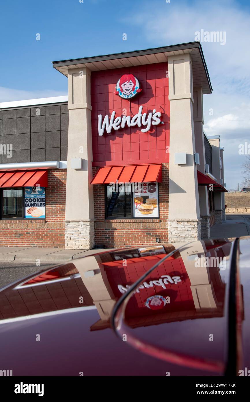 Maplewood, Minnesota. Wendy's Fastfood-Kette. Außenansicht des Gebäudes mit Logo und Reflexion auf der Motorhaube. Stockfoto