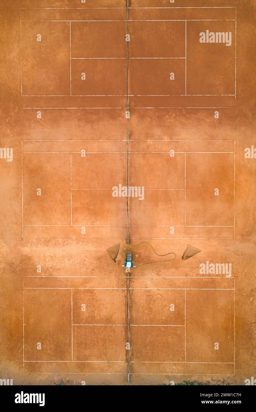 Die Drohne aus der Luft wurde oben unten auf einem leeren Tennisplatz mit Lehm-Spielplatz gedreht Stockfoto