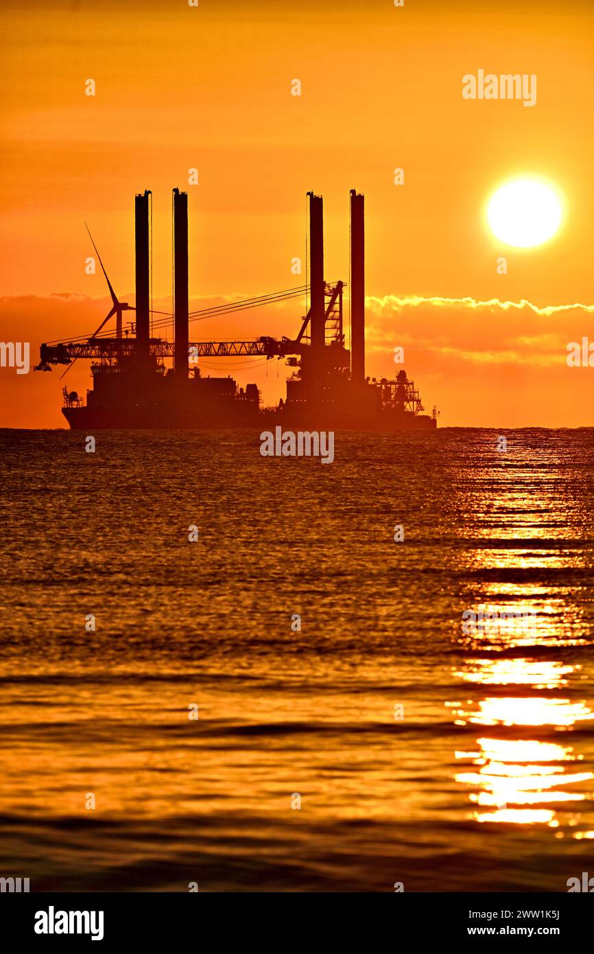 Vole Au Vent Offshore-Versorgungsschiff Jack Up Rig vor Anker in der Nordsee vor Blyth bei Sonnenaufgang mit goldenen Wolken und Sonne direkt darüber und golde Stockfoto