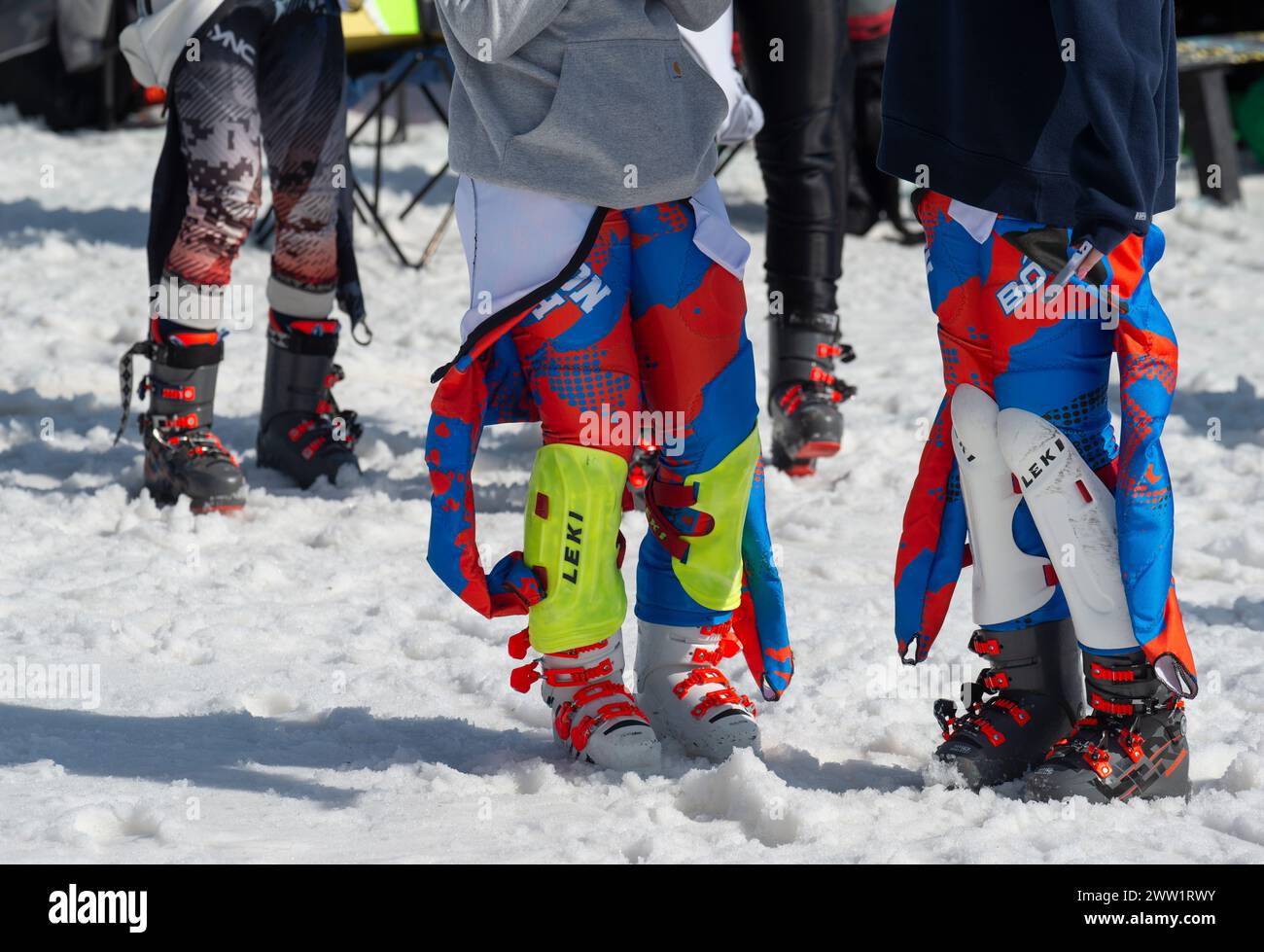 Massachusetts Interscholastic Athletic Association (MIAA) 2024 High School Alpinski jährliche Staatsmeisterschaft Slalom und Giant Slalom im Skigebiet Wachusett Mountain in Princeton, MA. Mehr als 300 Studenten nahmen an den Meisterschaften Teil. Zwei weibliche Rennfahrerinnen in Rennanzügen, schützender Polsterung und Skischuhen, die zwischen den Rennen sprechen. Stockfoto