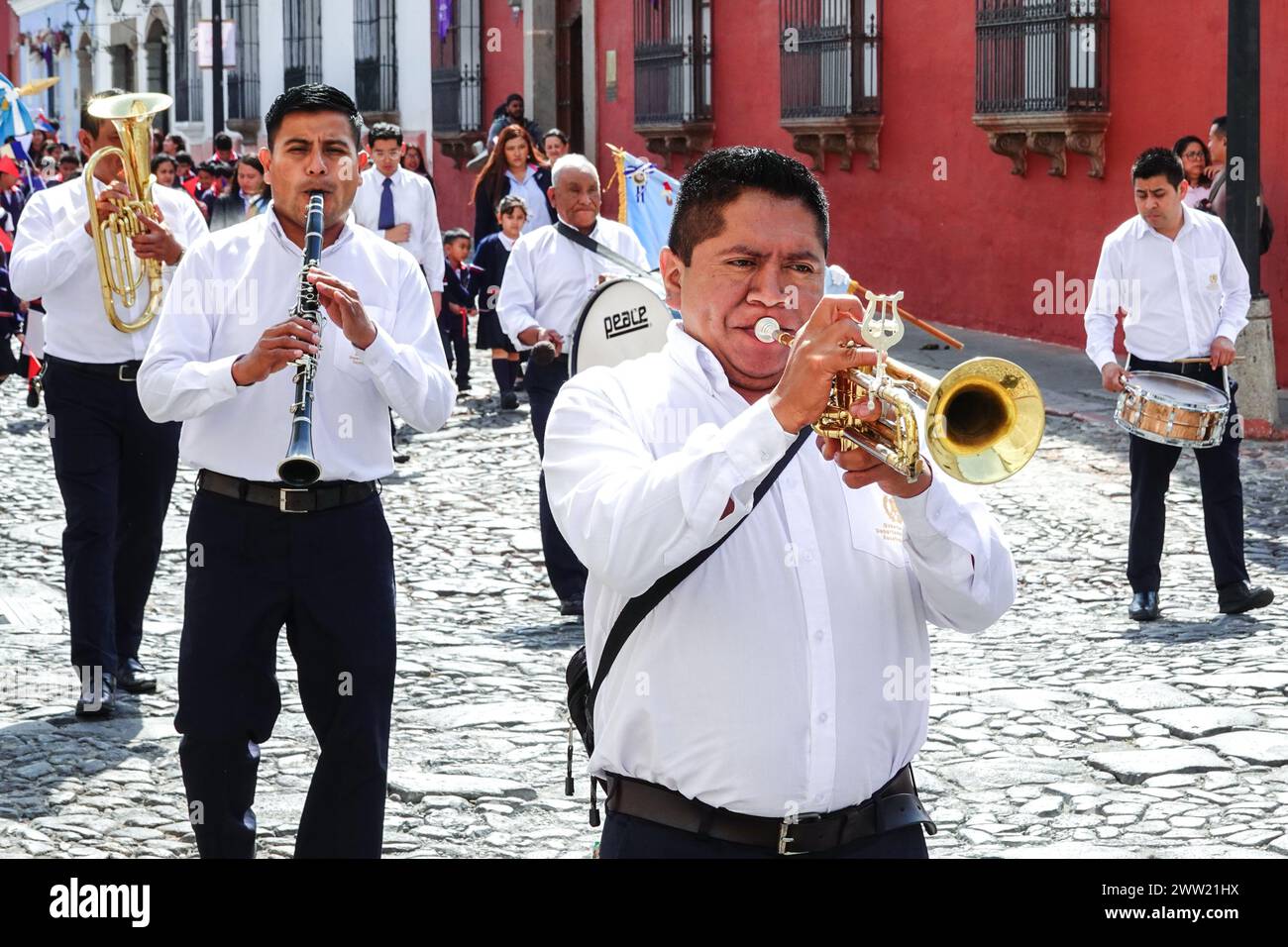 Antigua, Guatemala. März 2024. Eine Marschkapelle leitet die Semana Santa Festival Queen, umgeben von Schulkindern, während sie in Vorbereitung auf die Holly Week am 20. März 2024 in Antigua, Guatemala, durch das historische Zentrum zieht. Die opulenten Prozessionen, detailgetreuen Alfombras und jahrhundertealten Traditionen ziehen mehr als 1 Million Menschen in die alte Hauptstadt. Quelle: Richard Ellis/Richard Ellis/Alamy Live News Stockfoto