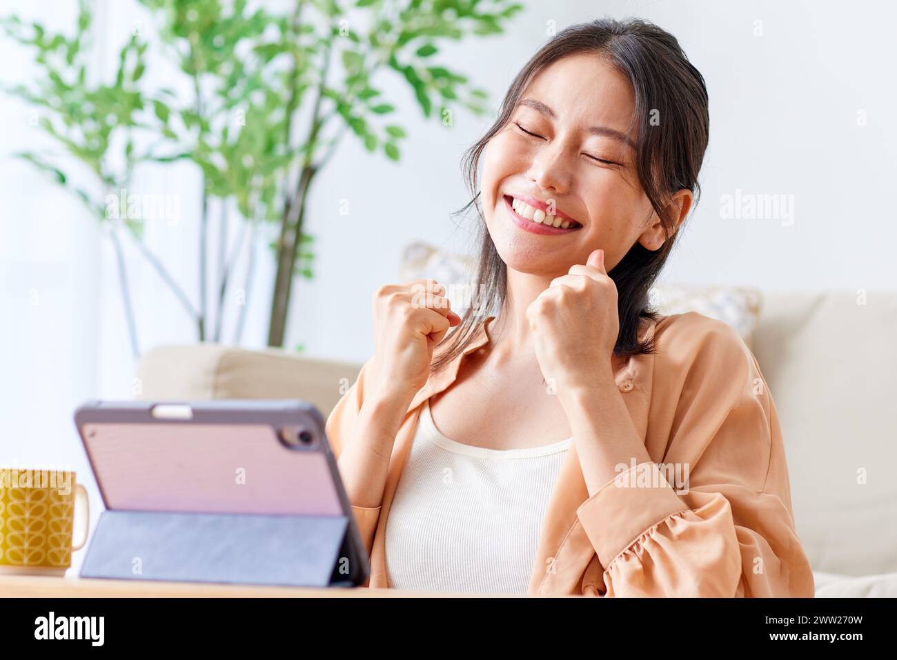 Eine Frau, die auf einer Couch sitzt und lächelt Stockfoto