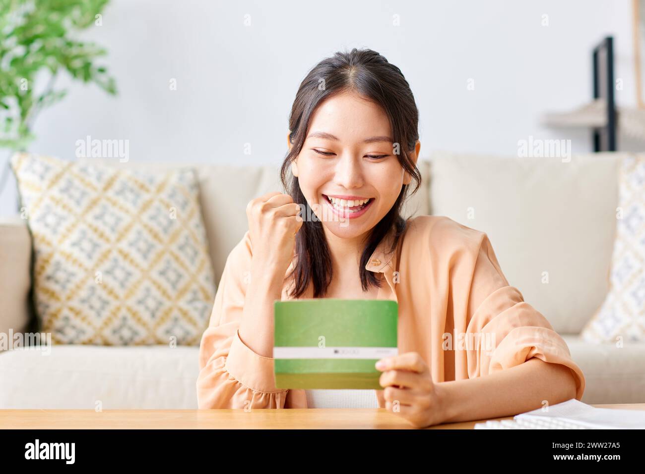 Eine Frau lächelt, während sie eine Banknote hält Stockfoto