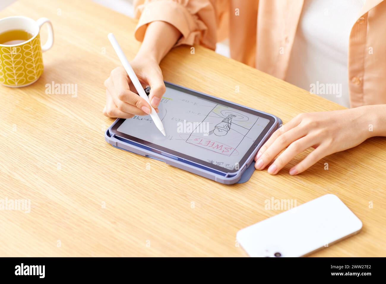 Eine Frau, die mit einem Stift auf eine Tablette schreibt Stockfoto