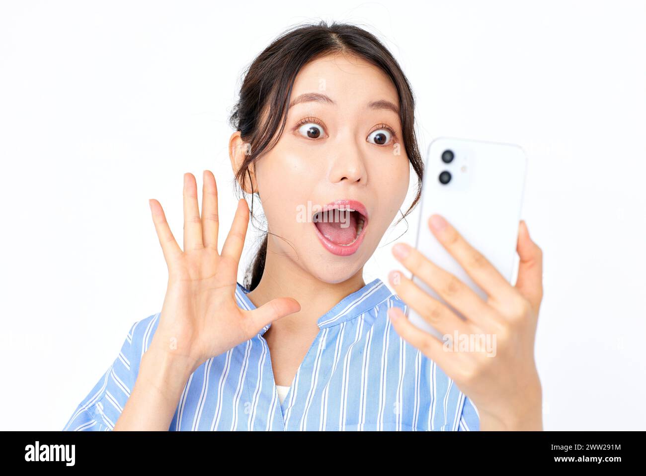 Eine Frau, die ihr Handy mit offenem Mund hält Stockfoto