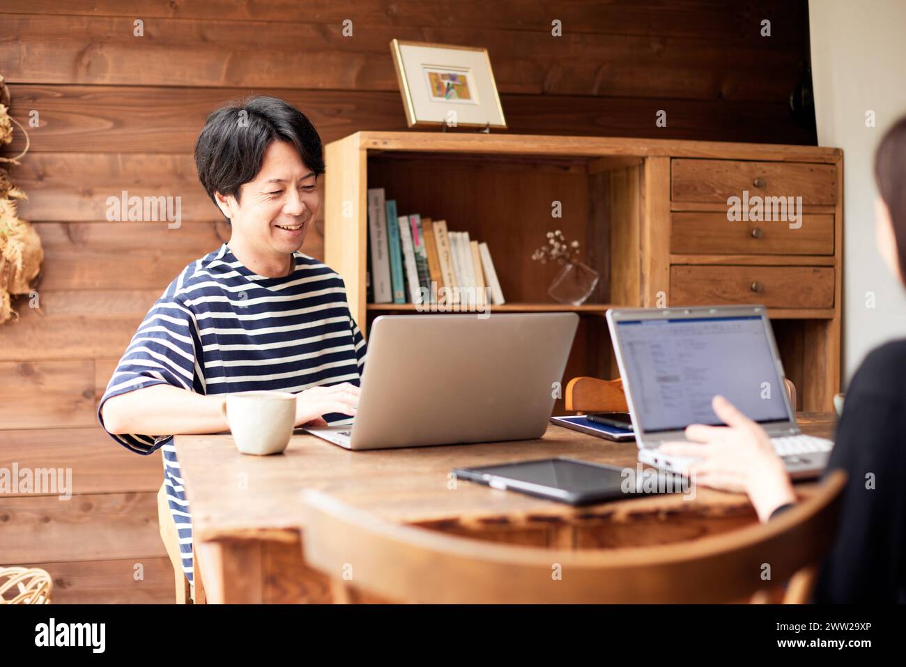 Ein Mann und eine Frau sitzen an einem Tisch mit Laptops Stockfoto
