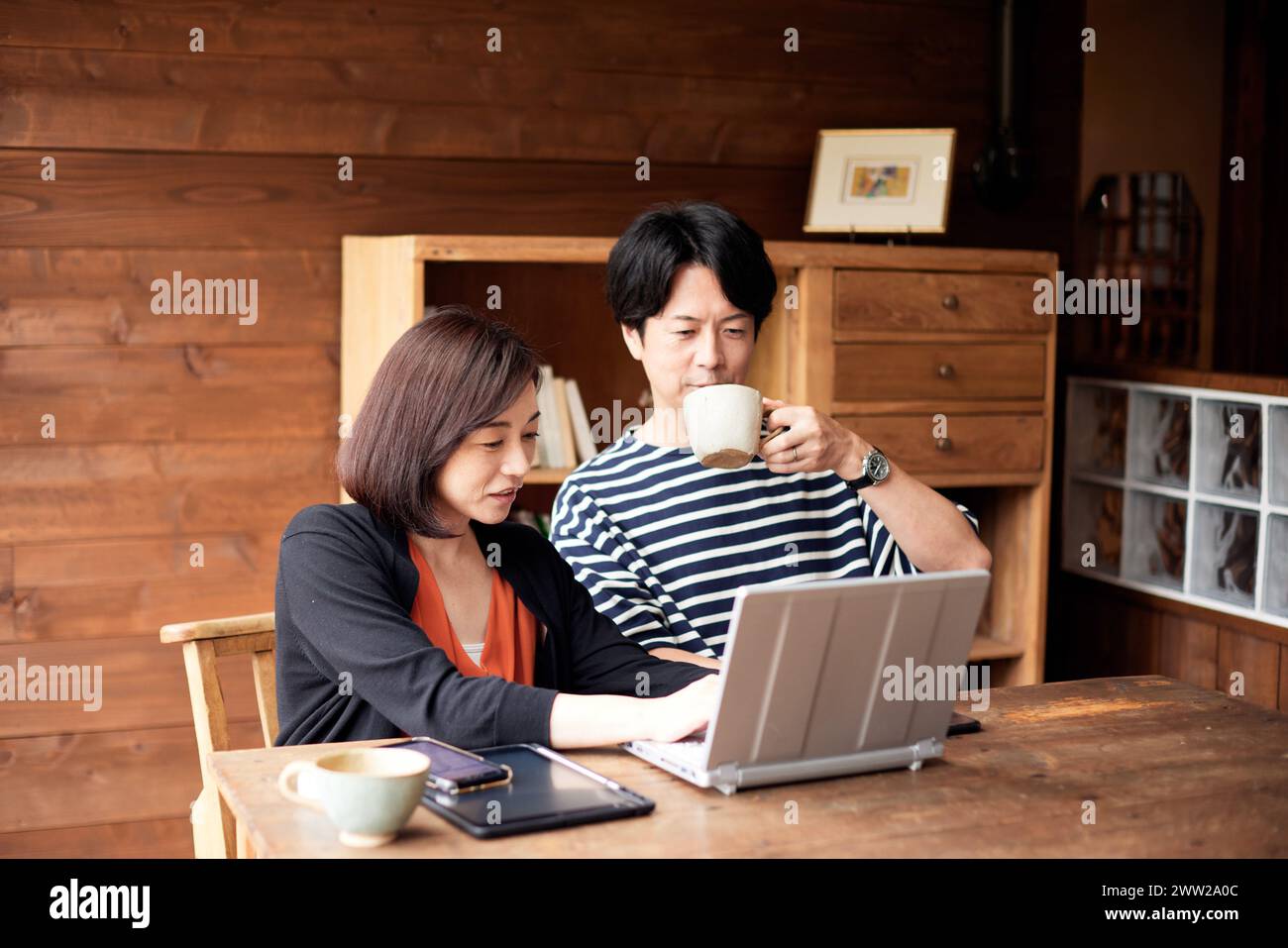 Ein Mann und eine Frau sitzen an einem Tisch mit Laptop Stockfoto