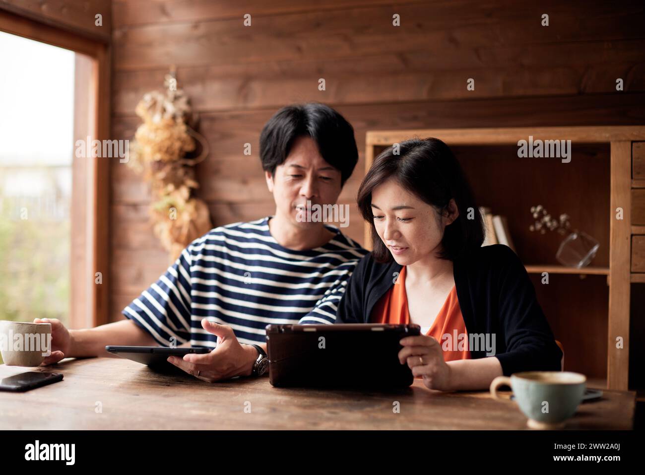 Asiatisches Paar, das zu Hause einen Tablet-Computer benutzt Stockfoto