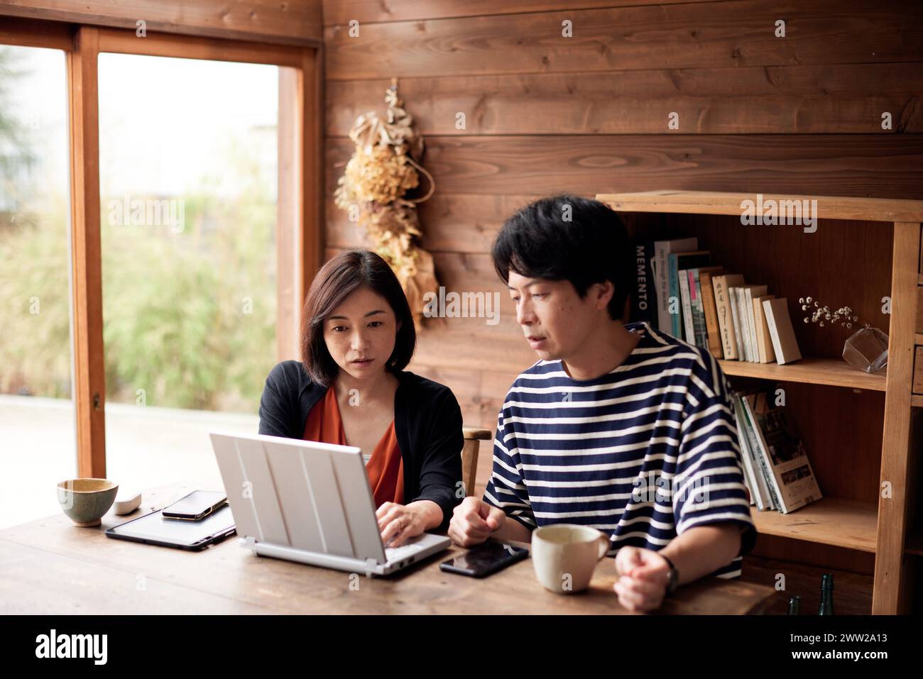 Ein Mann und eine Frau sitzen an einem Tisch mit einem Laptop Stockfoto