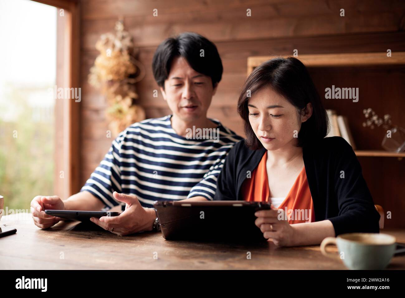 Asiatisches Paar, das zu Hause einen Tablet-Computer benutzt Stockfoto