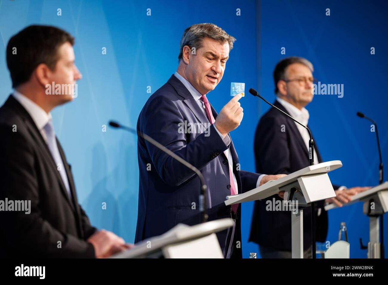 20. März 2024, Bayern, München: Markus Söder (CSU), Parteivorsitzender und Ministerpräsident Bayerns, zeigt die Zahlungskarte auf der Pressekonferenz zur Präsentation der bayerischen Zahlungskarte für Asylbewerber im Prinz-Carl-Palais am 20. März 2024. Daneben sind Sandro Kirchner (CSU), Staatssekretär im Bayerischen Innenministerium und Thomas Karmasin (CSU), Präsident des Bayerischen Kreisverbandes. Nach erfolgreichem Abschluss des Vergabeverfahrens wird in vier Pilotgemeinden, den Bezirken von, die Testphase der bayerischen Zahlungskarte für Asylbewerber beginnen Stockfoto