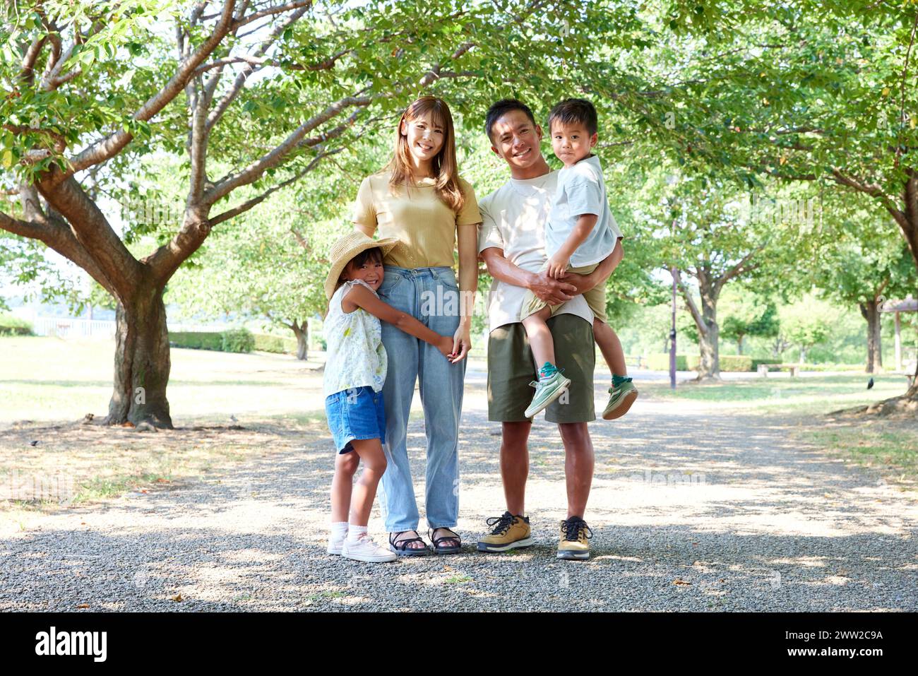 Eine Familie, die in einem Park unter Bäumen steht Stockfoto