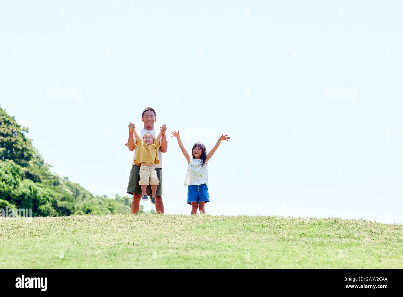 Ein Mann und zwei Kinder stehen auf einem Hügel Stockfoto