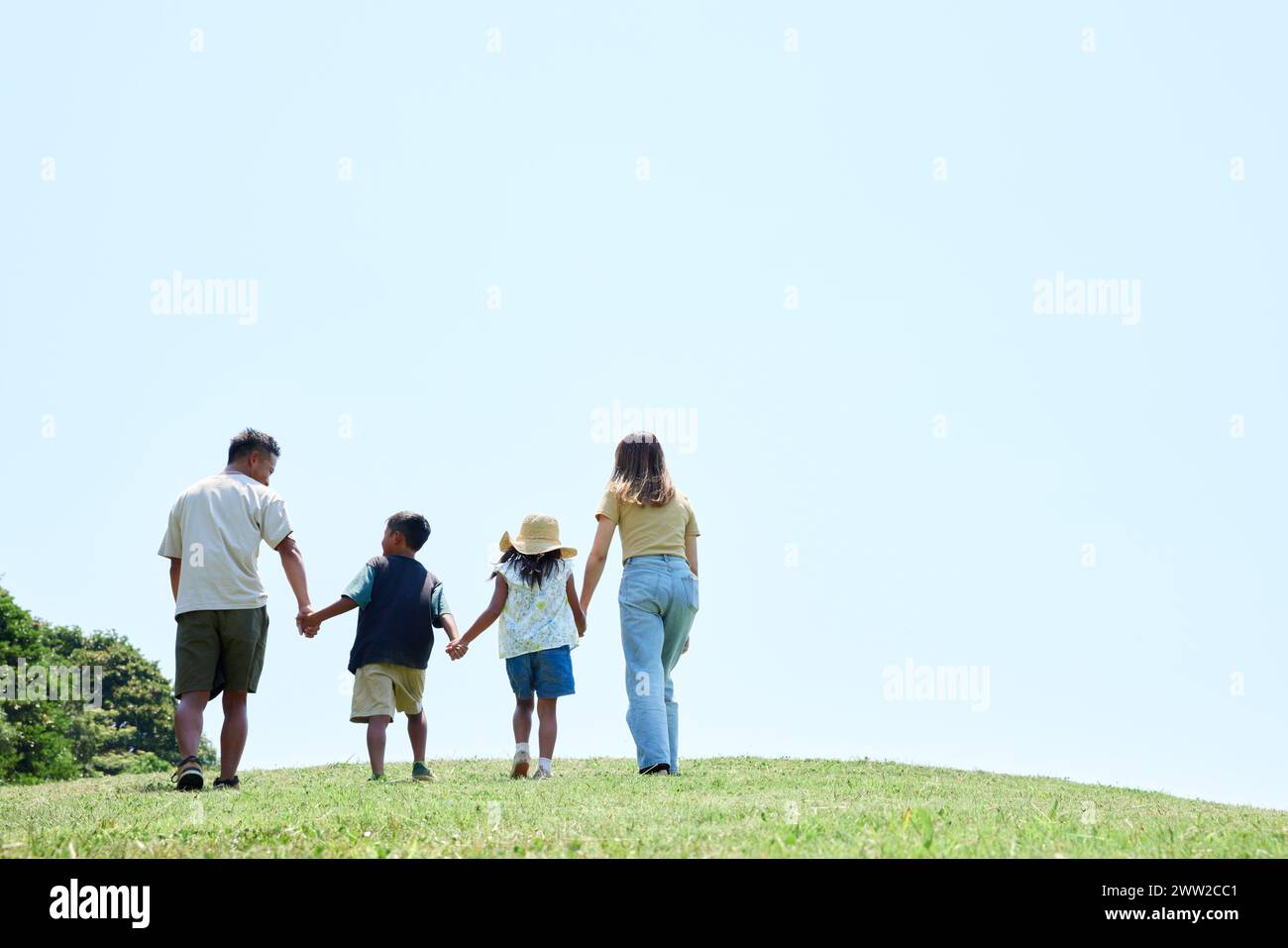 Eine Familie, die auf einem grasbewachsenen Hügel läuft Stockfoto