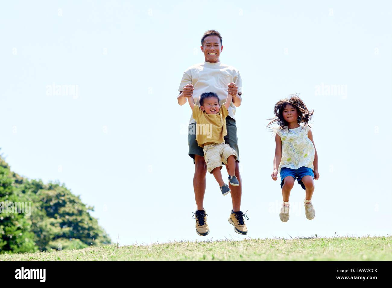 Ein Mann und zwei Kinder springen in die Luft Stockfoto