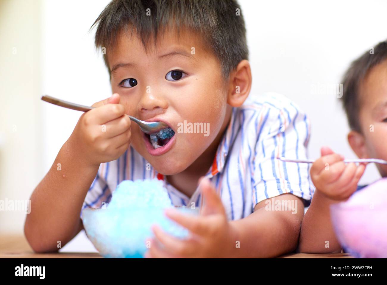 Zwei Kinder essen rasiertes Eis Stockfoto