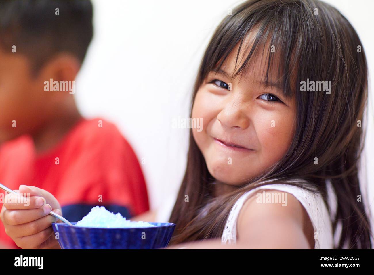 Ein Kind isst rasiertes Eis Stockfoto