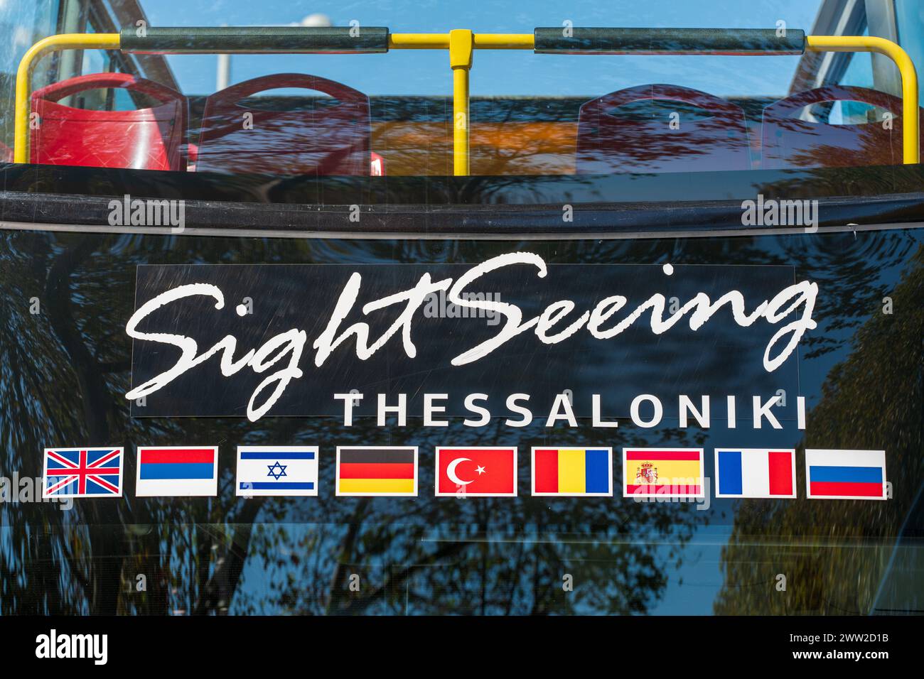 Panorama City Tour Bus. Glasreflexion. Blauer Himmel. Besichtigungstouren in Thessaloniki. Verschiedene nationale Flaggen. Großbritannien, Russland, Israel, Deutschland Stockfoto