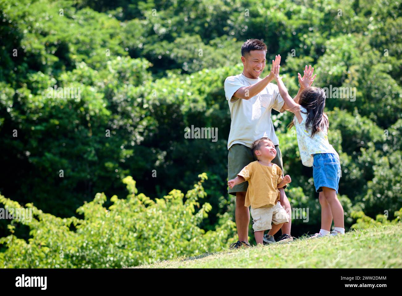 Ein Mann und zwei Kinder stehen auf einem Hügel Stockfoto