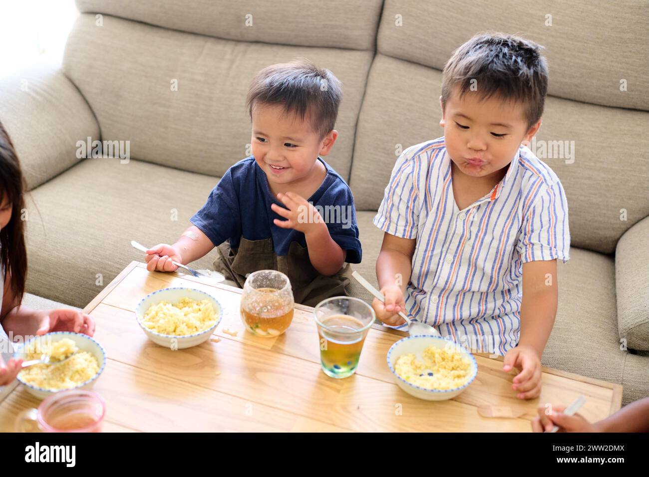 Kinder, die an einem Tisch sitzen und Essen essen Stockfoto