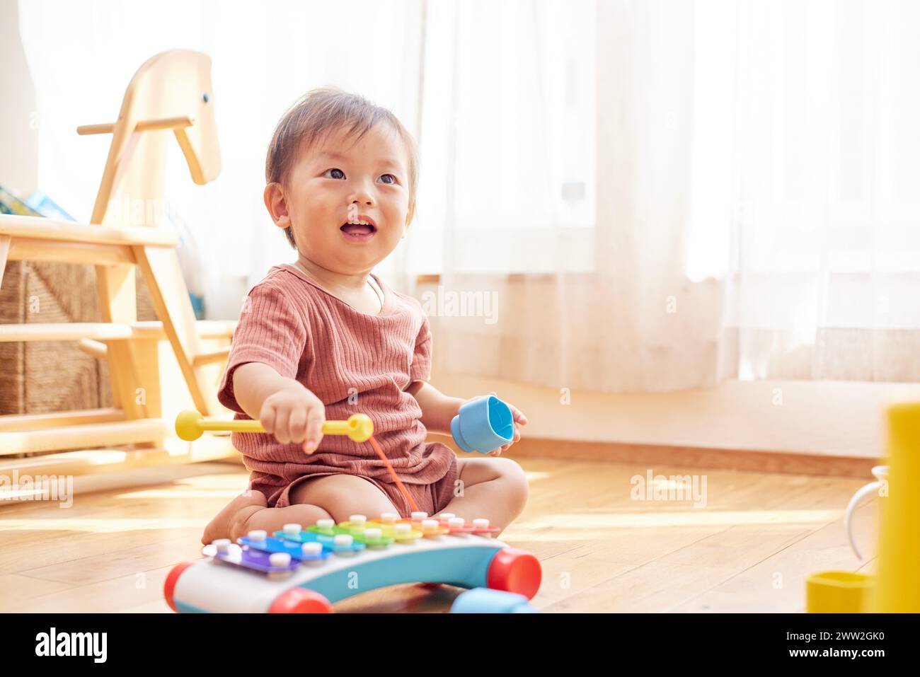 Ein Baby, das mit Spielzeug auf dem Boden spielt Stockfoto