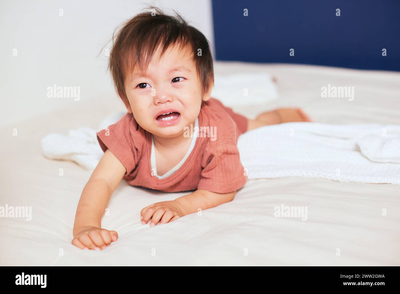 Ein Baby, das auf einem Bett weint Stockfoto