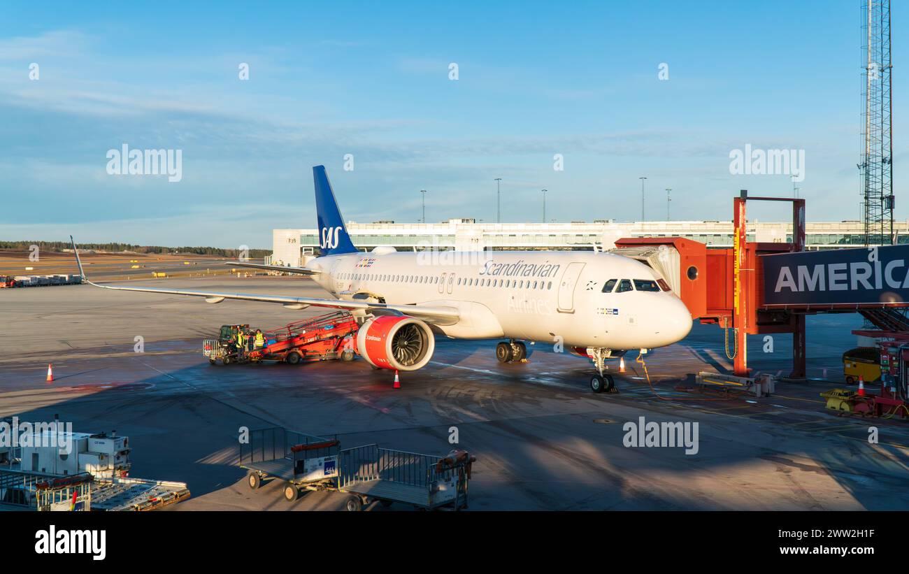 Skandinavische Fluggesellschaften Airbus A320 Flugzeuge am Gate am Flughafen Arlanda, Bodenabfertiger warten das Flugzeug. Klarer Himmel. Schweden Stockfoto