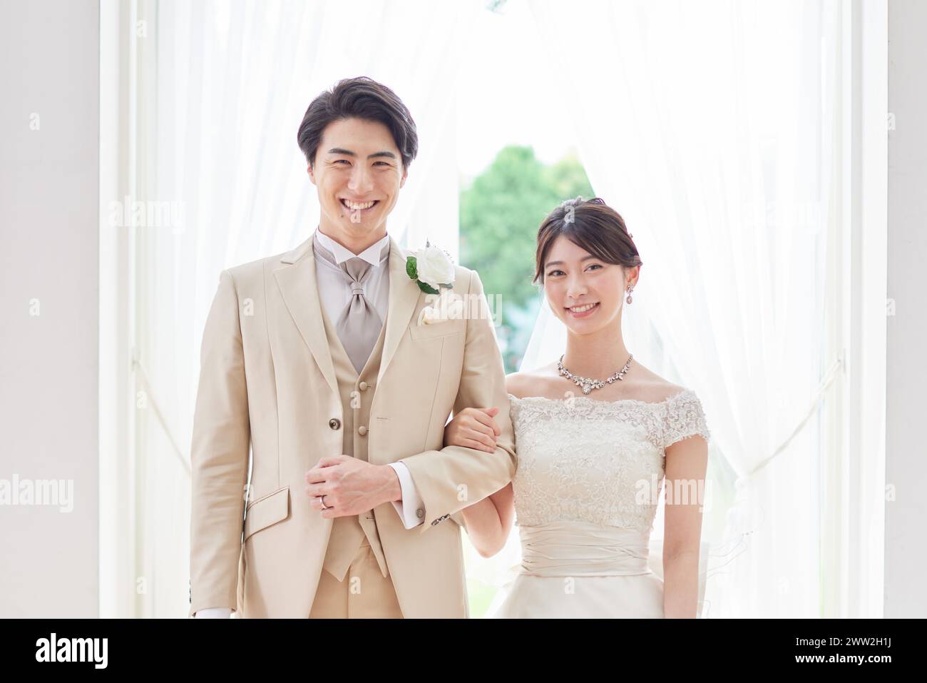 Ein Mann und eine Frau in Hochzeitskleidung stehen nebeneinander Stockfoto