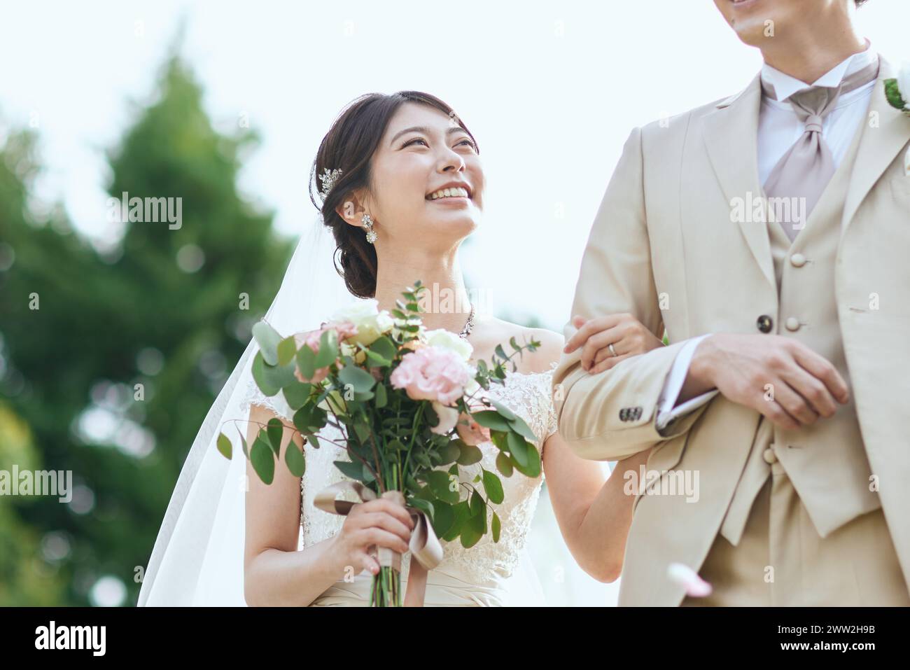 Eine Braut und ein Bräutigam lächeln, während sie zusammen stehen Stockfoto