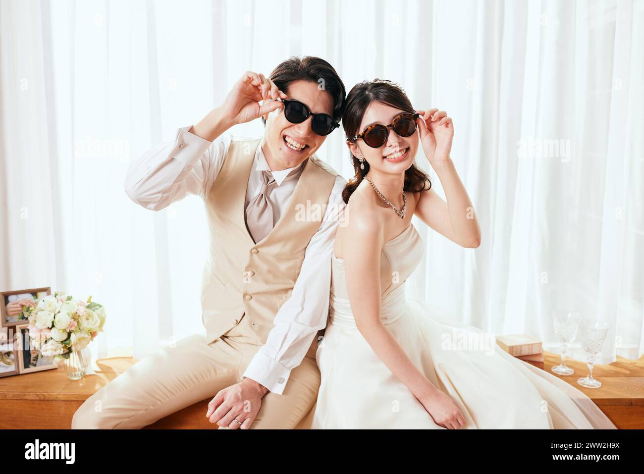 Eine Braut und ein Bräutigam in Sonnenbrille posiert für die Kamera Stockfoto