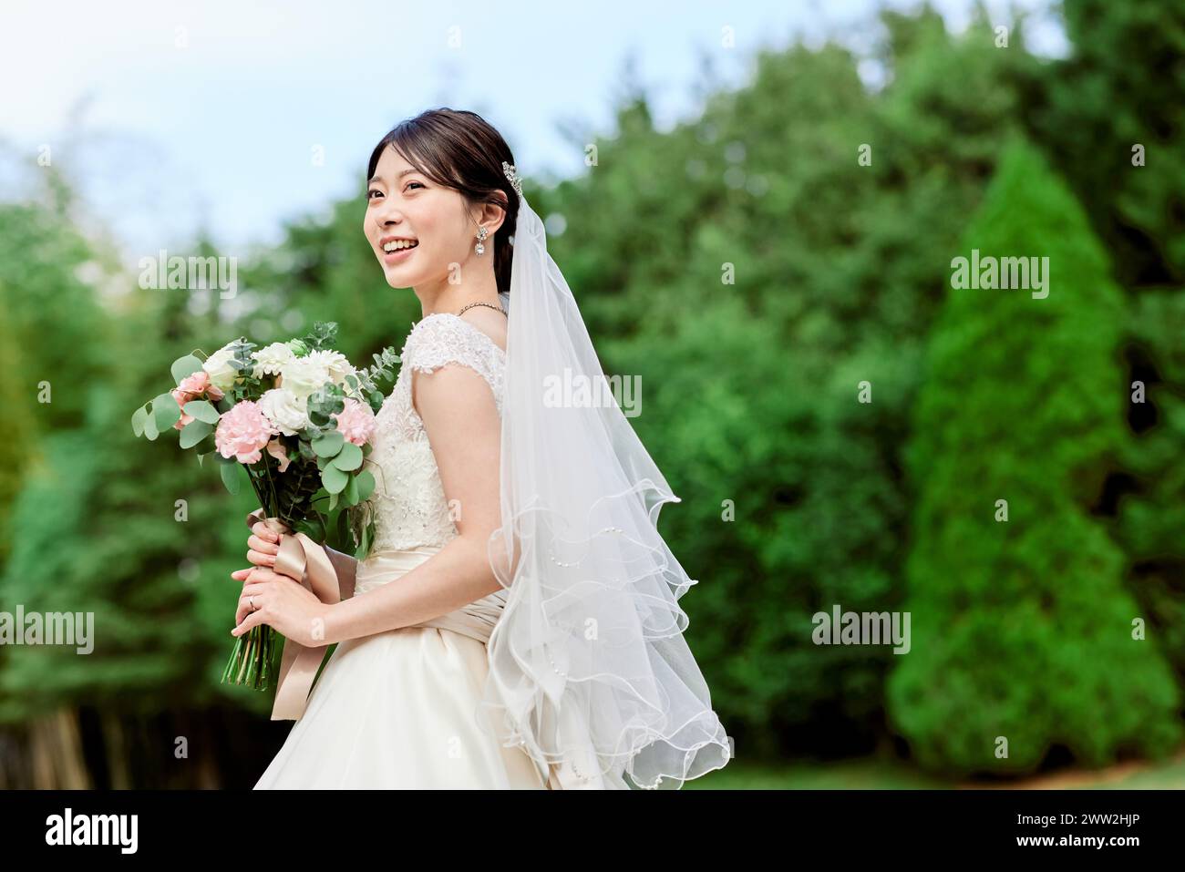 Eine Braut in einem Hochzeitskleid mit einem Blumenstrauß Stockfoto