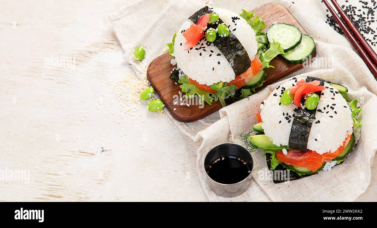Moderne Hybridkost. Sushi-Burger mit Lachs, weißem Reis, Avocado, Gurke. Kopierbereich Stockfoto