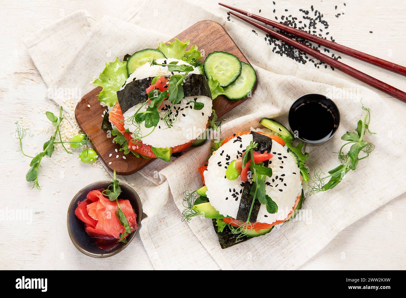 Moderne Hybridkost. Sushi-Burger mit Lachs, weißem Reis, Avocado, Gurke. Draufsicht Stockfoto