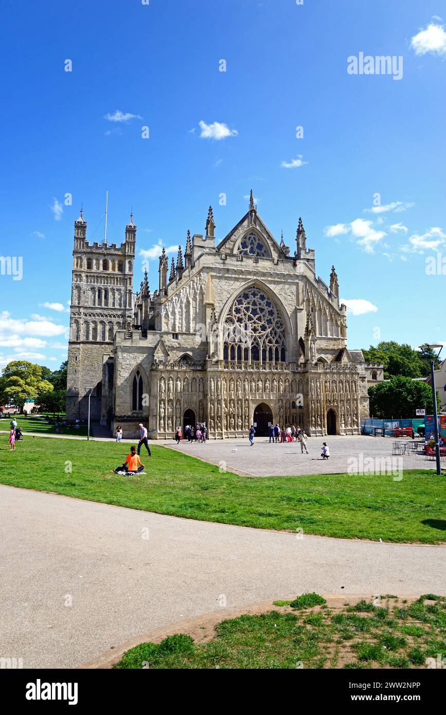 Vorderansicht der Kathedrale (Kathedrale St. Peter in Essex) mit Touristen, die die Umgebung genießen, Exeter, Devon, Großbritannien, Europa. Stockfoto
