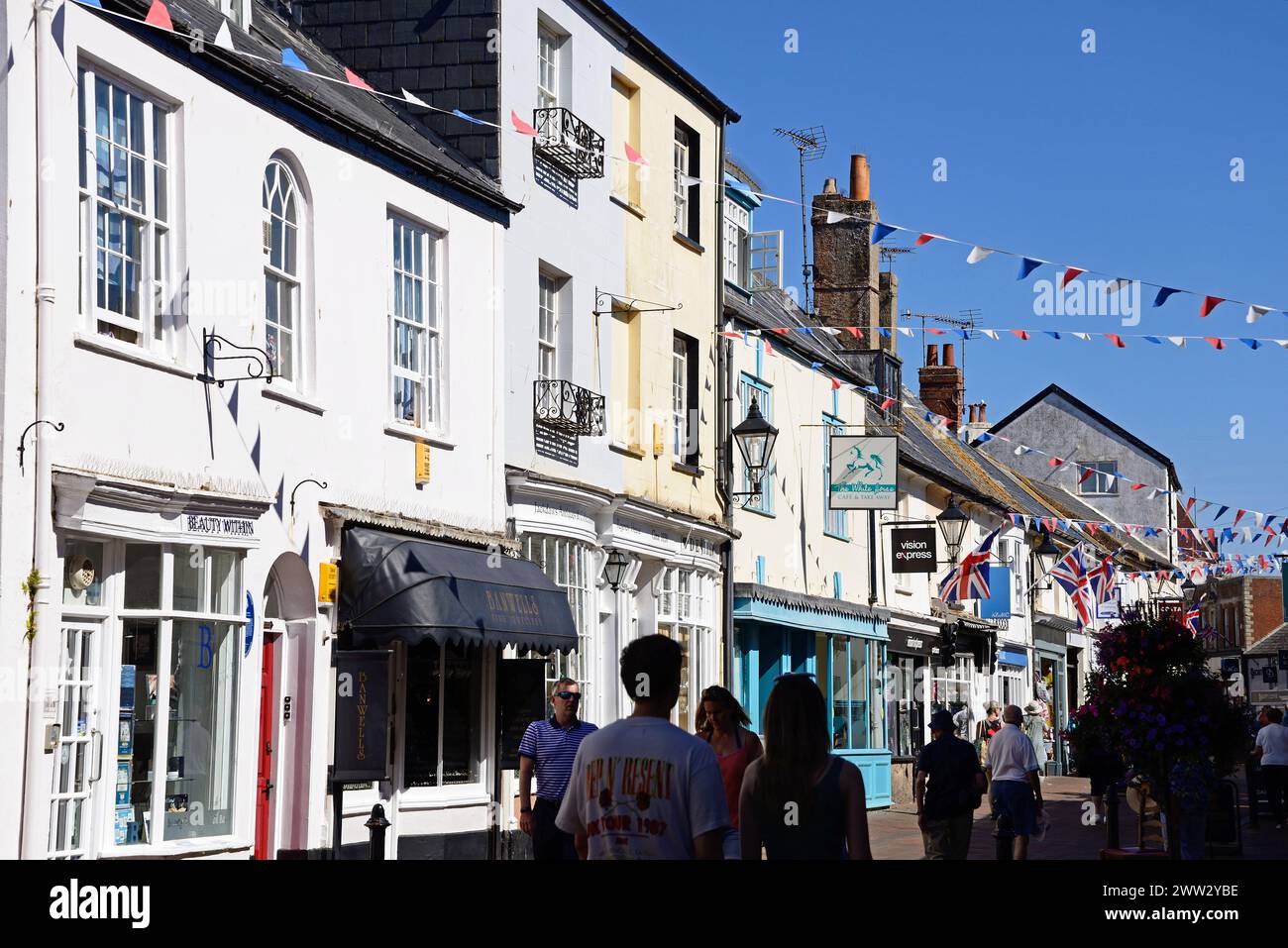 Shopper und Geschäfte entlang der Old Fore Street im Stadtzentrum, Sidmouth, Devon, Großbritannien, Europa. Stockfoto