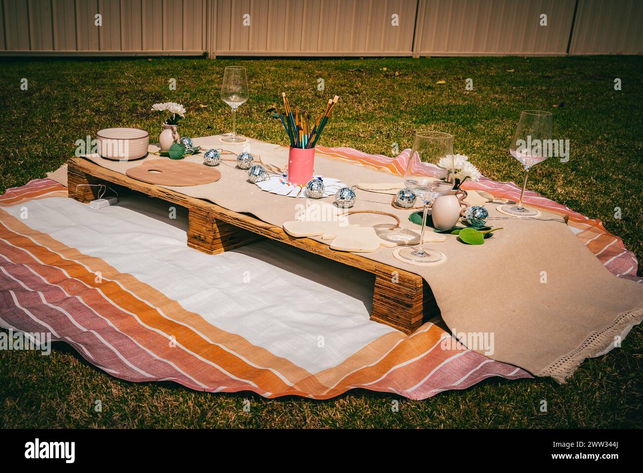 Kunstzubehör und Picknick-Essentials unter dem warmen Glanz eines sonnigen Tages. Stockfoto