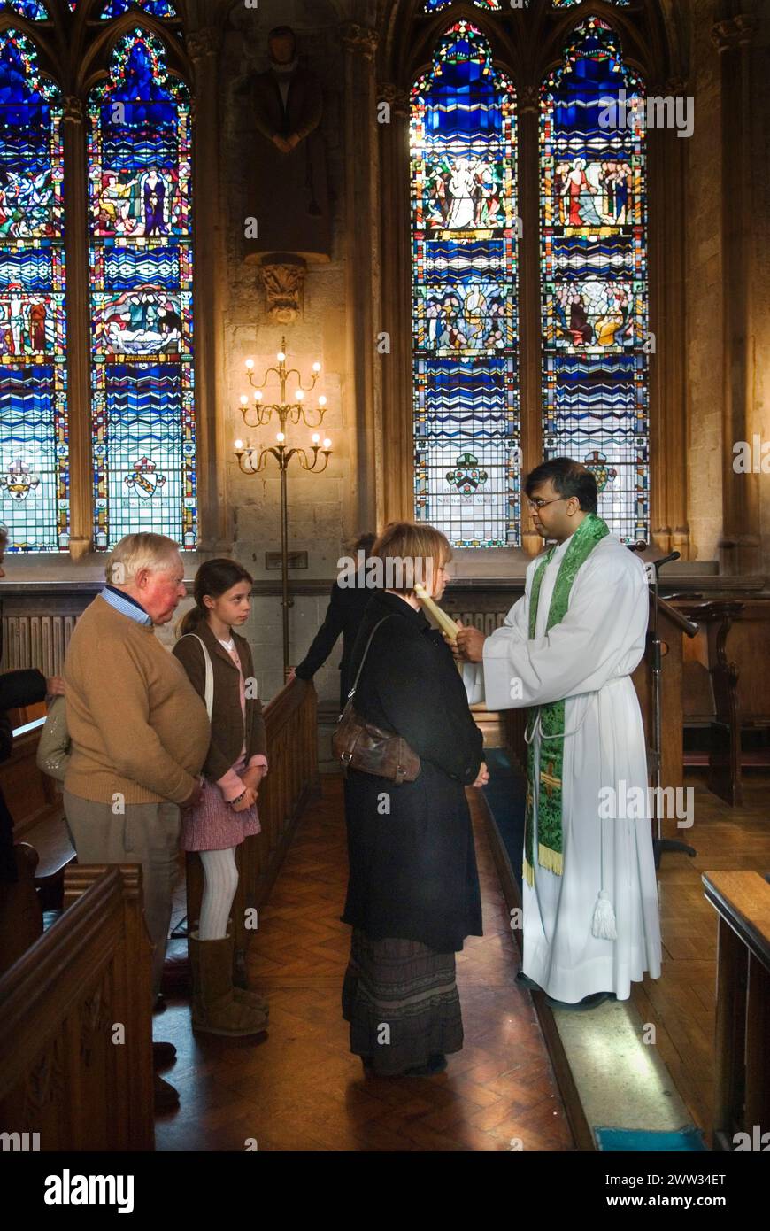 Katholiken, jung und alt, stehen sich an, um vom römisch-katholischen Priester gesegnet zu werden, in einem jährlichen katholischen Ritual der Zeremonie des Throats, 3. Februar Kerzen werden an beiden Seiten der Kehle platziert. Die katholische Kirche St. Etheldreda. Ely Place London. HOMER SYKES AUS DEN 2000ER JAHREN Stockfoto