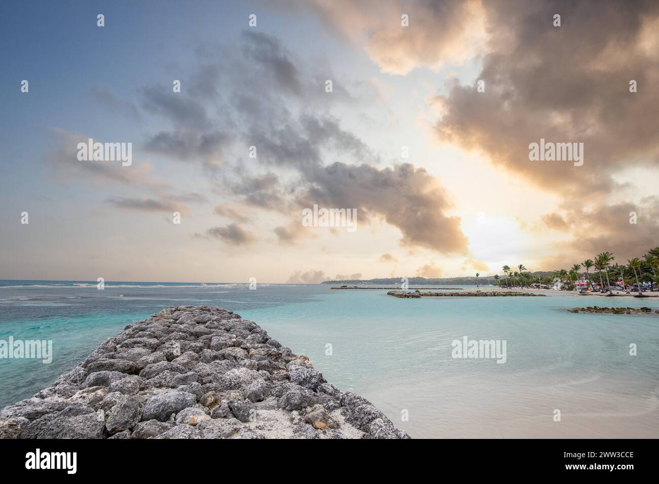 Karibischer Traumstrand mit Palmen, weißem Sandstrand und türkisfarbenem, kristallklarem Wasser im Meer. Flache Bucht bei Sonnenuntergang. Plage de Stockfoto