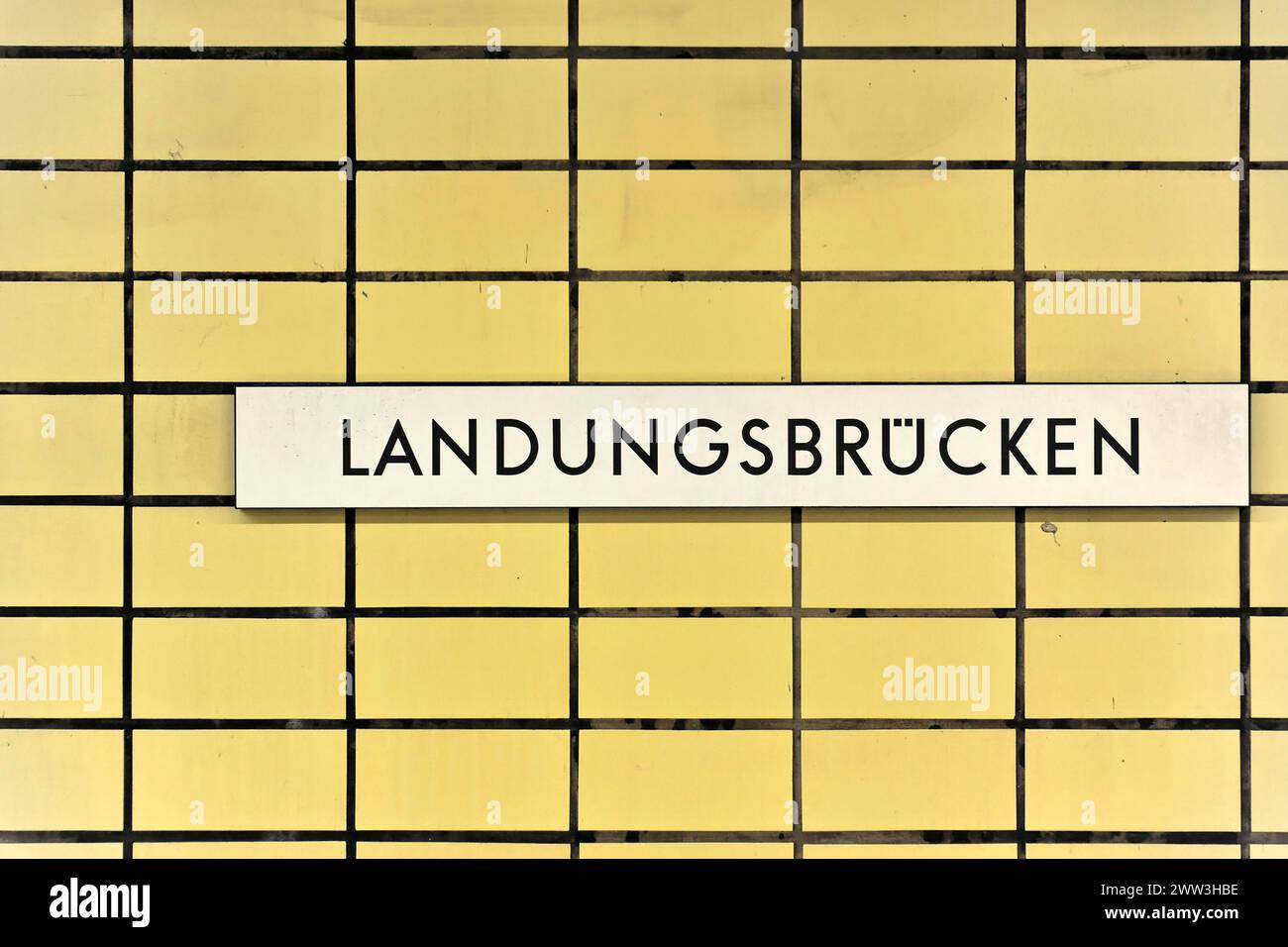 Ein Schild mit der Aufschrift „Landungsbrücken“ auf einer gelb gekachelten Wand, Hamburg, Hansestadt Hamburg, Deutschland Stockfoto