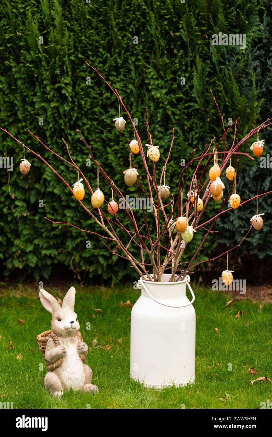 Ein Osterhase aus Porzelan mit einem Osterstrauß mit Ostereiern im Garten. Symbolfoto, Themenfoto *** Ein Porzellan-Osterhase mit Ostereierstrauß im Garten Symbolfoto, Themenfoto Foto:XB.xSchubertx/xFuturexImagex ostern 4301 Stockfoto