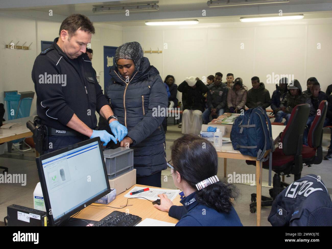 Flüchtlinge werden von der Bundespolizei in Rosenheim registriert und registriert. Ein Polizist macht einen Fingerabdruck-Scan, 05/02/2016 Stockfoto