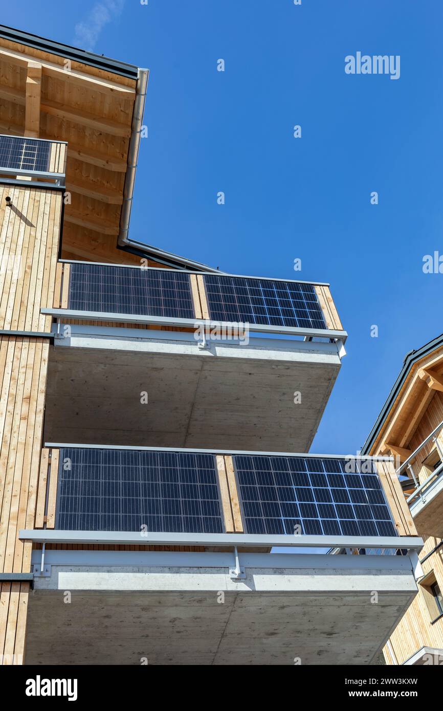Sonnenkollektoren auf den Balkonen eines Holzhauses Stockfoto