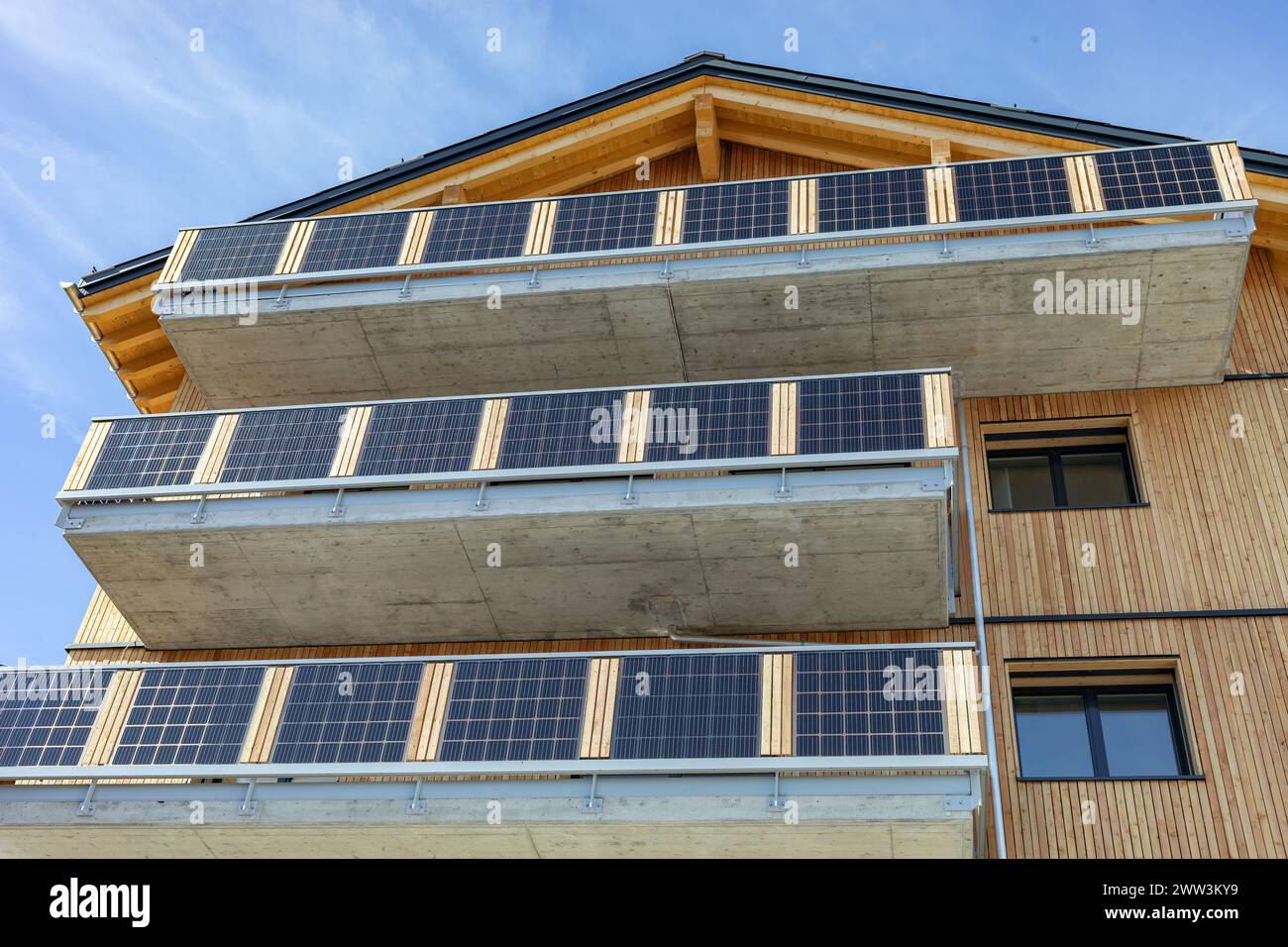 Wohngebäude mit großen Betonbalkonen, die mit Solarzellen bedeckt sind Stockfoto