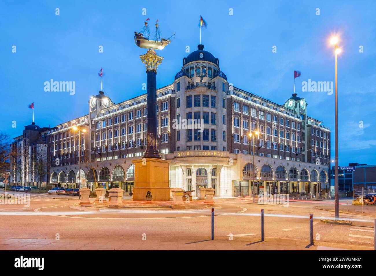 Stoertebeker-Haus an der Blauen Stunde mit Granitsäule und Schiff, das eine Nachbildung von Stoertebeker's Cog, Hamburg, Deutschland, darstellt Stockfoto