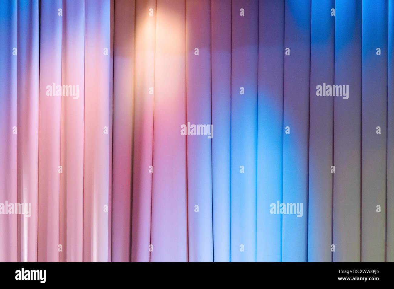 Geschlossener Theatervorhang mit blauen und rosafarbenen Spotlichtern, Hintergrundfotostruktur Stockfoto