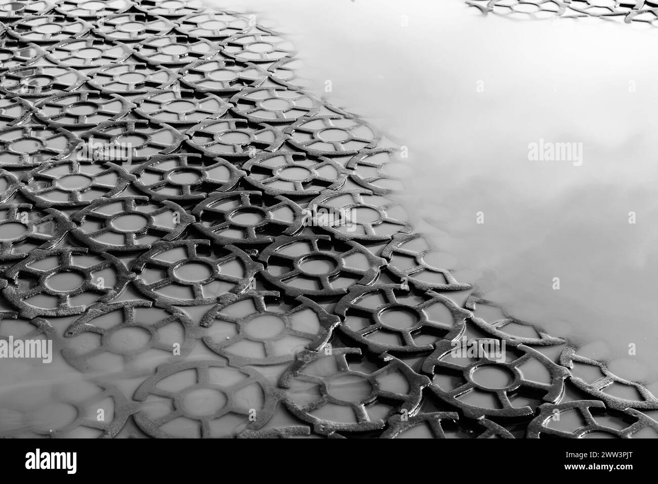 Stahlfliesen, Straßenbelag für Industrieanlagen. Abstrakter Schwarzweiß-Fotohintergrund Stockfoto