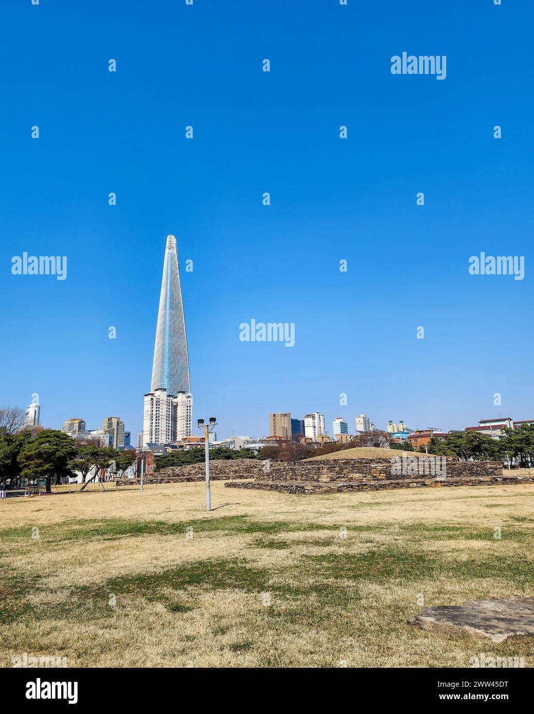 Seoul, Südkorea - das antike Grab von Baekje Seokchon mit dem Lotte World Tower im Hintergrund Stockfoto