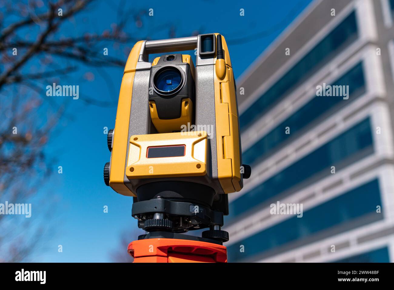 Landvermessungsgerät auf einem Stativ mit einem Gebäude im Hintergrund Stockfoto