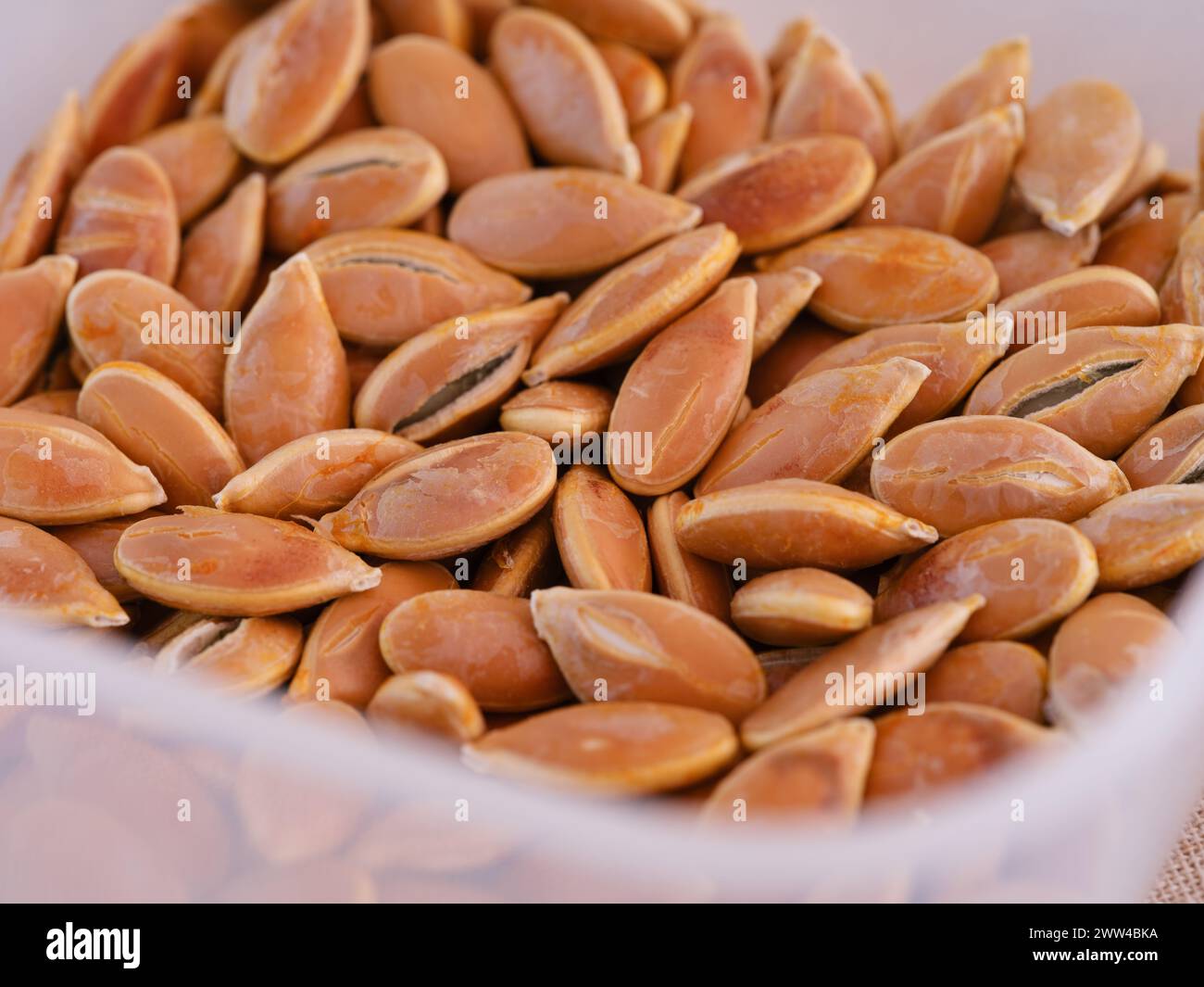 Eine Nahaufnahme von Kürbissamen in einem Plastikbehälter. Stockfoto